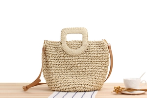 Detail of hand-woven beige paper rope bag with square hollow handle and leather strap