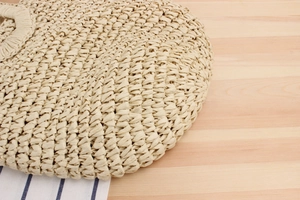Detailed close-up of tight cross-weave texture on a beige paper rope summer bag