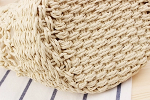 Close-up of intricate woven paper rope texture on a minimalist vacation handbag