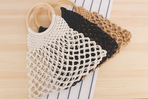 Detailed close-up of handmade macramé woven bags with round wooden handles in three colors