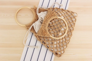 Detail of hand-woven cotton rope mesh bag with bamboo handle and drawstring liner