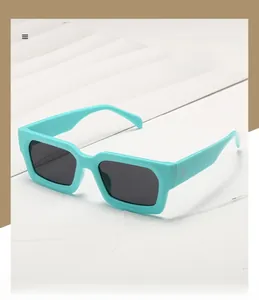 Détail de lunettes de soleil carrées polarisées avec monture cyan et rivets argentés