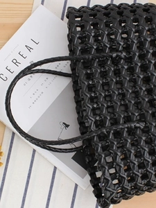 Modern black woven PVC handbag with wide lattice design and minimalist top handle
