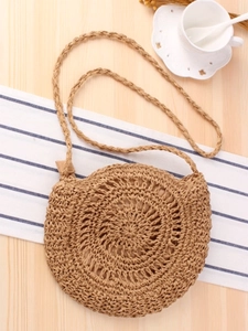 Handmade round woven straw crossbody bag with bow detail and spiral texture for beach vacation