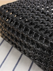 Minimalist black PVC woven tote bag with a close-up of the stylish mesh texture