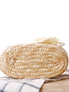 Bottom view of handmade straw woven handbag with spiral texture and lace details