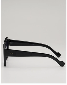 Close-up of black square sunglasses with metallic rivets and product specifications on the arm