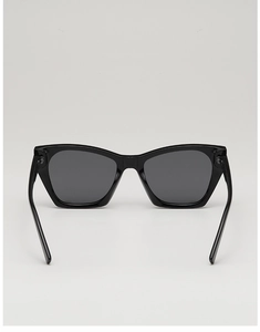 Close-up of black oversized cat-eye sunglasses with polished frame and dark lenses