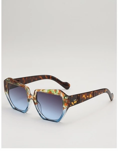 Detail of square oversized tortoiseshell sunglasses with gradient lenses and metal rivets