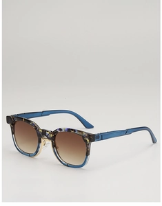 Détail de lunettes de soleil léopard avec pont en métal doré et plaquettes de nez
