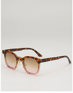Détail de lunettes de soleil rétro en écaille rose avec pont métallique doré élégant
