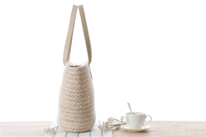 Close-up of beige woven beach bag with leather handles and interior lining