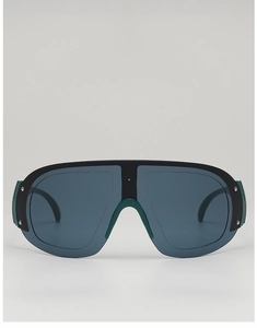 Close-up of oversized shield sunglasses with green nose pads and metallic rivet details