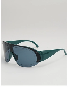 Close-up of oversized shield sunglasses with deep green frame and metal rivets