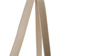Close-up of beige leather handle featuring white contrast stitching on a woven straw bag