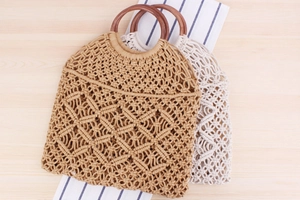 Détail d'un sac bohème tissé à la main avec poignées en bois et motif de filet en coton