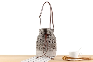 Detailed close-up of woven paper rope bucket bag with hollow diamond crochet pattern