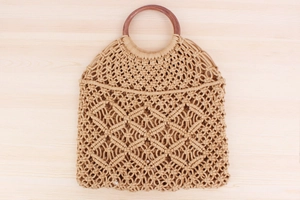Dettaglio macro della tessitura macramé fatta a mano e del manico circolare in legno scuro