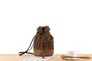 Detailed macro view of woven bucket bag texture with drawstring and leather strap