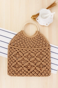 Dettaglio della borsa bohémien in cotone intrecciata a mano con manici in legno