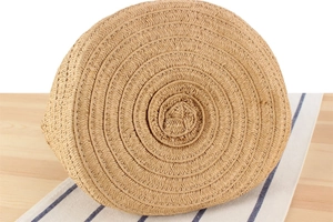 Detailed view of the spiral woven base of a straw bucket bag crafted from natural fiber