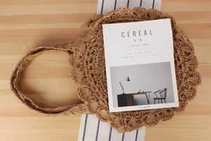 Detail of hand-woven paper rope shoulder bag with wavy edges and round hollow design