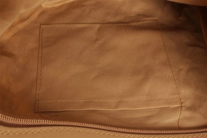 Detail of the paper rope woven bag interior showing brown fabric lining and open pocket