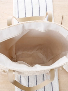 Straw tote bag with linen lining and leather handles on a rustic table background