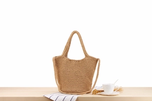 Texture détaillée d'un sac cabas en paille tressée sur bois avec tasse et fleurs séchées