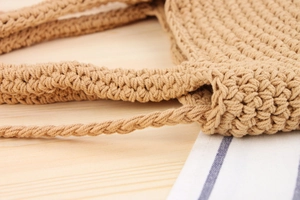 Gros plan détaillé sur la texture crochetée à la main d'un sac tissé de couleur beige