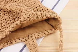 Gros plan du sac tissé caramel montrant la texture des fibres et la doublure