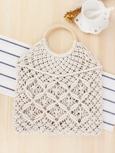 Sac à main tissé macramé beige avec poignées en bois sur fond en bois clair