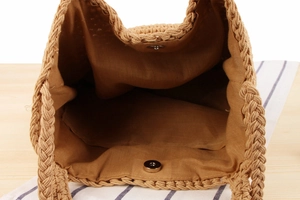 Détail de l'intérieur du sac tissé avec doublure marron foncé et fermoir magnétique en métal