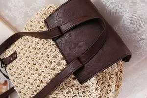 Detail of woven paper straw texture and dark brown leather straps on a vintage backpack