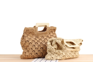 Détail de sacs en paille bohèmes avec poignées carrées en bois et motifs tissés