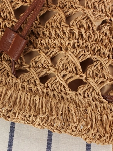 Hollow out woven paper rope bucket bag with brown leather accents for beach vacation