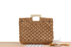 Détail du sac cabas en paille tissé main avec anses en bois et motifs de tricot en éventail