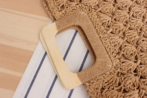 Détail de la poignée en bois carrée et de la corde en papier tressée sur le sac de plage