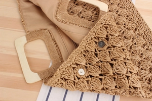 Détail du sac en paille tissé avec poignée en bois, doublure tissu et fermoir magnétique