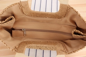 Détail du sac tissé main avec doublure en tissu kaki, fermeture éclair et poignée bois