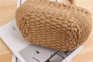Detailed close-up showing the handmade woven texture of the straw beach tote bag