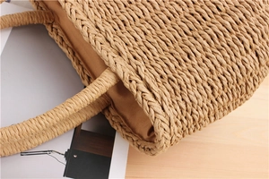 Detailed view of handmade woven straw tote bag with reinforced handles and fabric lining