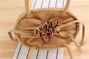 Detailed top view of handmade woven straw bag with drawstring lining and round handles