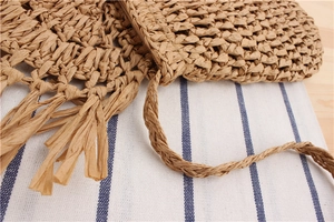 Detail view of handmade crochet bag showing hollow grid texture and long tassels