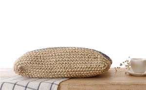 Détail d'un sac en paille de papier tissé à la main avec bordure colorée sur bois