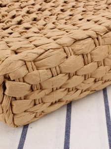 Handcrafted woven straw tote bag with natural fiber texture for leisure and vacation use