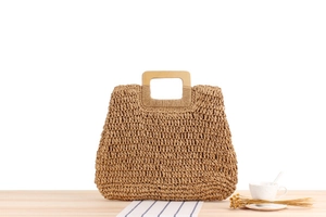 Détail du sac en paille tissé main avec anses carrées en bois et texture artisanale