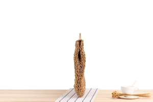 Détail du sac cabas en paille tressée montrant le profil latéral et la texture main