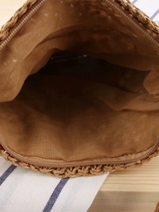 Handmade brown woven straw crossbody bag featuring secure zipper closure and fabric lining