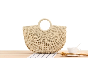 Detail of hand-woven straw beach bag with hollow mesh pattern and fabric lining
